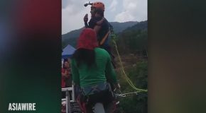 Man Holding His Young Daughter Bungee Jumps of Bridge